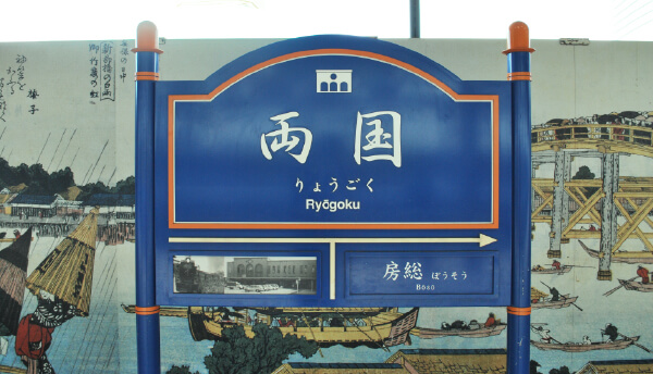 写真：「両国」と書かれた青とオレンジの駅看板